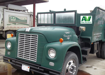 Vintage green garbage truck with AVI logo